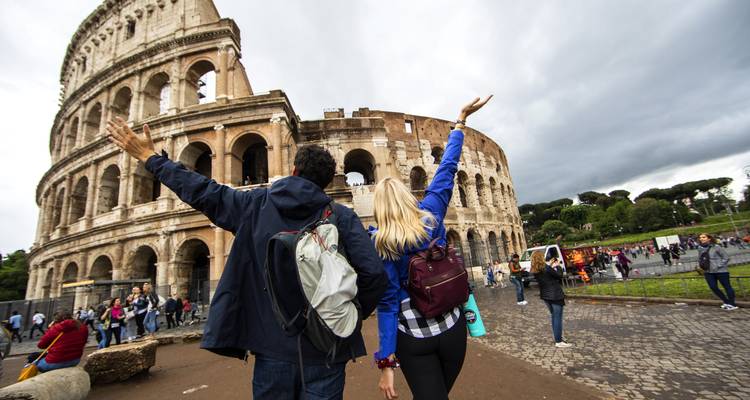 Personas con las manos alzadas frente al Coliseo en Roma.
