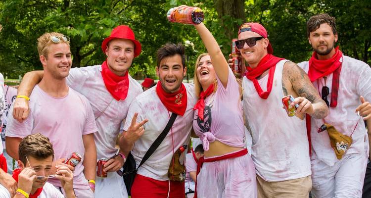 Groupe d'amis posant en vêtements de fête avec des écharpes rouges.