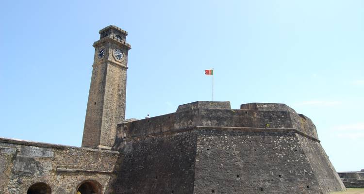 Historische Festung mit einem Uhrenturm unter klarem blauen Himmel.