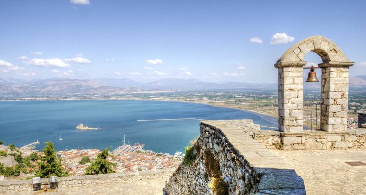 Zicht op een kuststad met een gewelfde stenen klokkentoren.