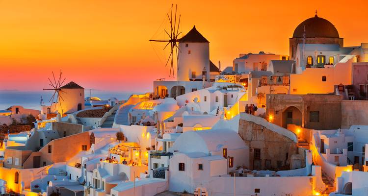Santorini dorp bij zonsondergang met oranje en roze tinten.
