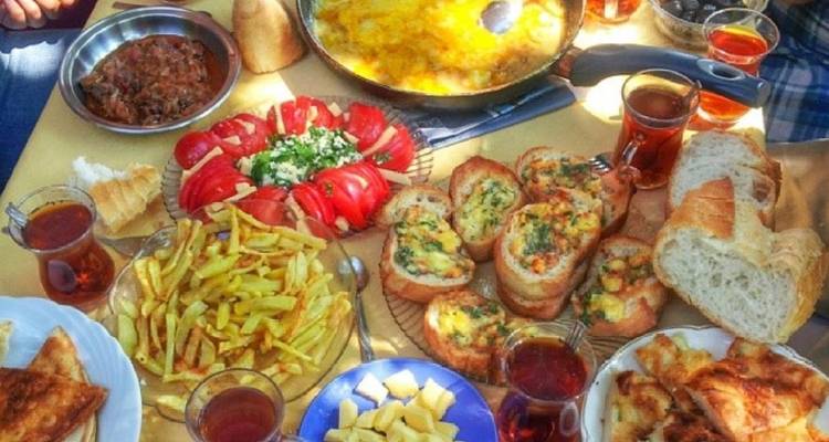 Mesa llena de una variedad de comidas y bebidas locales.