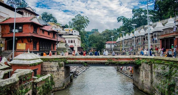 Vue de la ville avec une rivière, un pont et des temples.