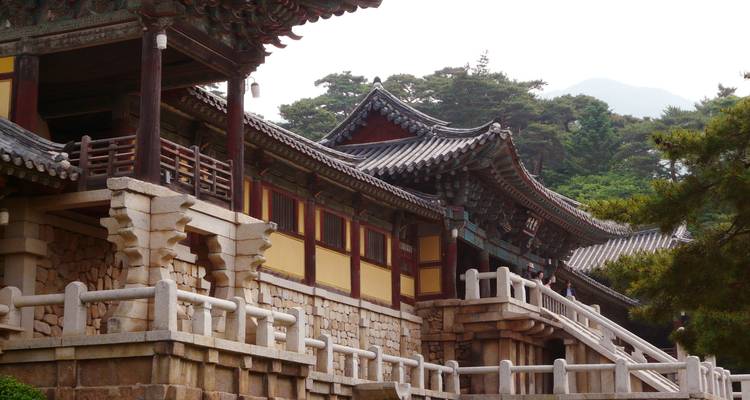 Traditional Korean architecture with a mountainous background.