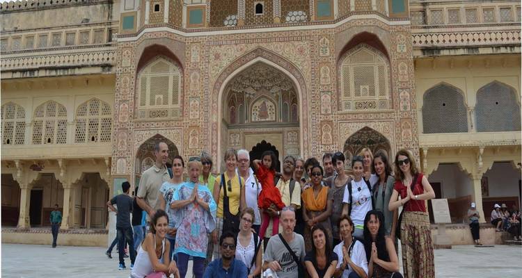 Tourists posing in front of the intricate design of Amber Fort.