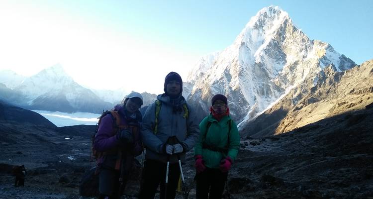 Des randonneurs prenant la pose devant une montagne enneigée.