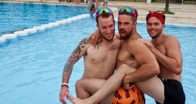 Trois hommes posant près d'une piscine.