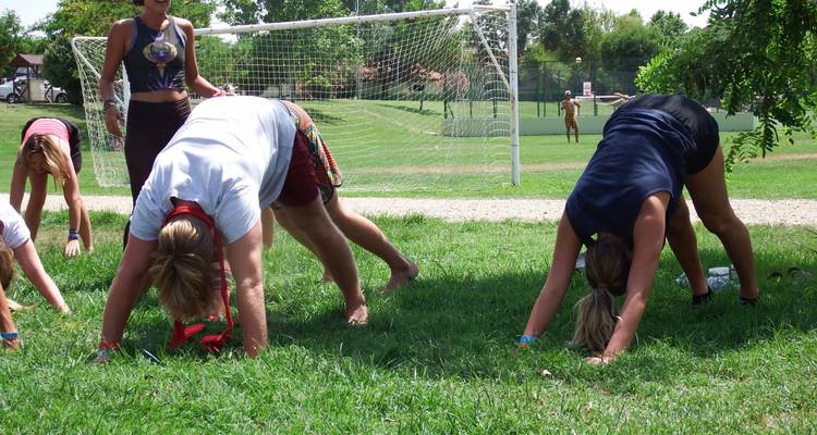 Des gens faisant des exercices en plein air sur l'herbe.