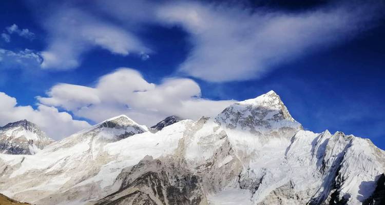 Panoramisch uitzicht op majestueuze besneeuwde bergen onder een diepblauwe hemel.