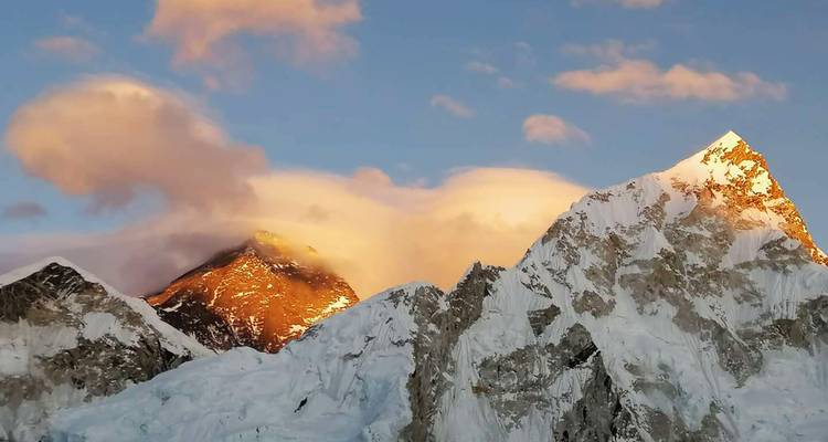 Zonsopgang boven een panoramisch uitzicht op besneeuwde bergtoppen.