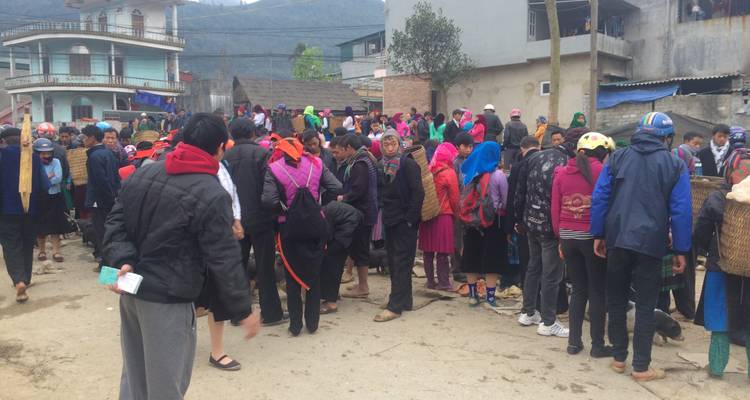 Gran grupo de personas reuniéndose en una zona rural.