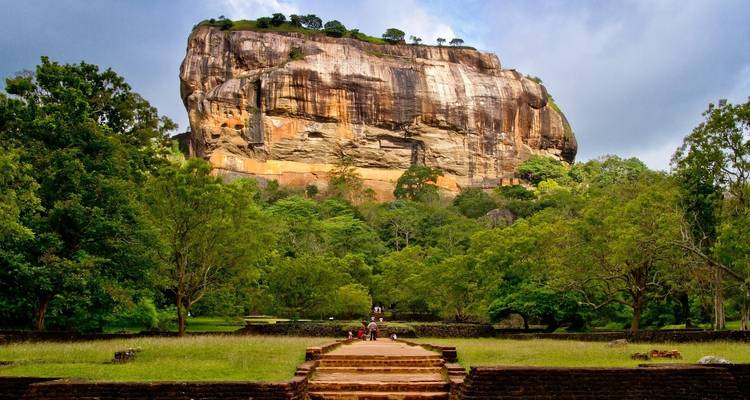 Famous rock fortress with stairs surrounded by greenery.