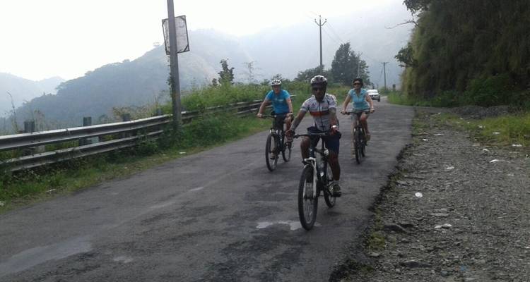 Three bikers riding on a rural road.