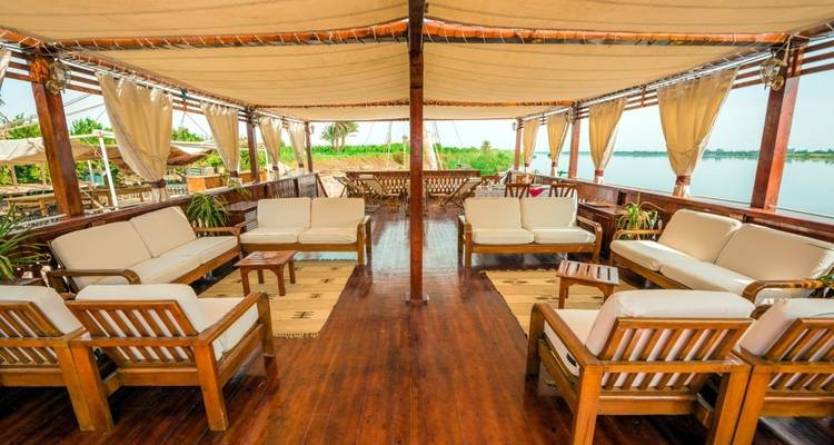 Interieur van een boot met comfortabele zitplaatsen en uitzicht naar buiten.