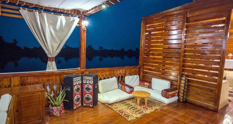 Bootdek 's nachts met informele zitplaatsen en luidsprekers.