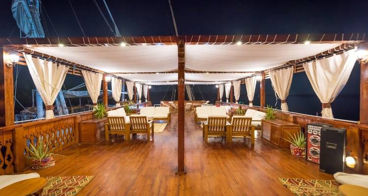 Bovendek van een luxe boot 's nachts met zitplaatsen.