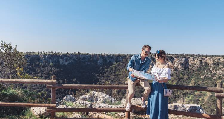 Un couple regardant une carte avec un beau ravin en arrière-plan.