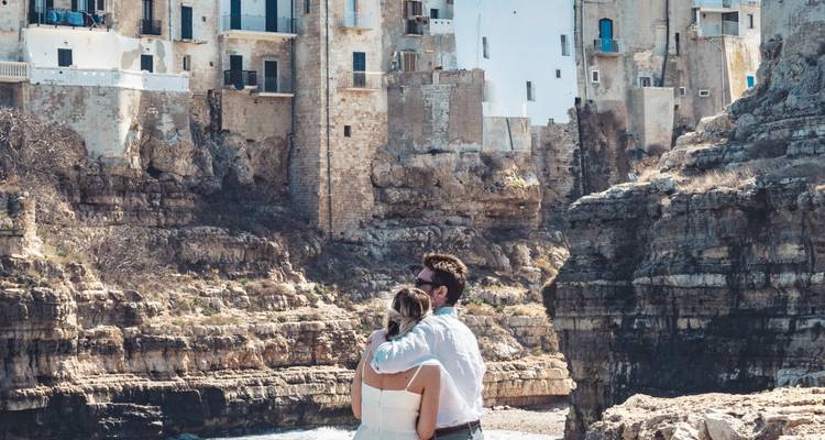 Couple s'embrassant près d'une falaise côtière.