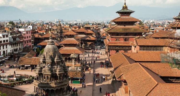Vue aérienne d'une ville historique avec des temples et des montagnes.