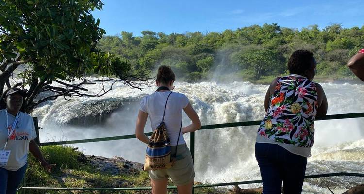 Mensen die bij de reling staan en uitkijken over een waterval.