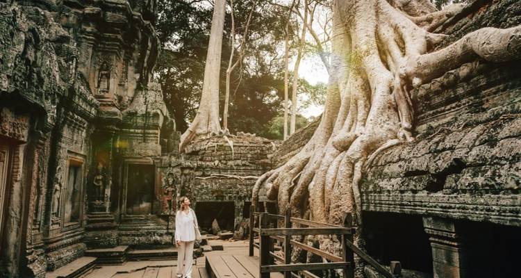 Vrouw die ruïnes met boomwortels observeert bij Ta Prohm.
