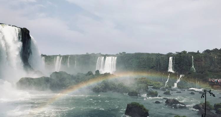 Waterfalls with a rainbow forming over the misty water.