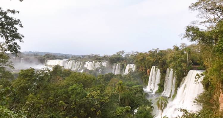 Wide view of cascading waterfalls amidst rainforest.