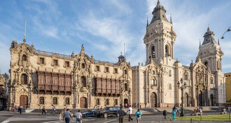 Personas caminando frente a la catedral histórica de Lima.
