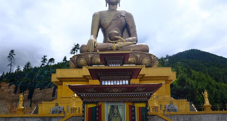 Grote gouden Boeddhabeeld op een versierd platform.