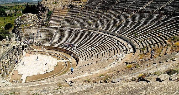 Amphithéâtre antique avec des personnes qui l'explorent.