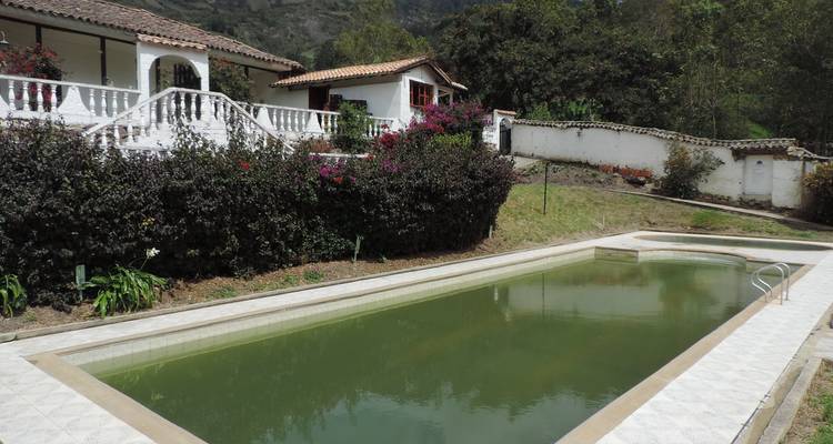 Pequeña piscina al aire libre con una casa rústica.
