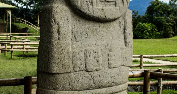 Ancienne sculpture en pierre dans un champ ouvert.