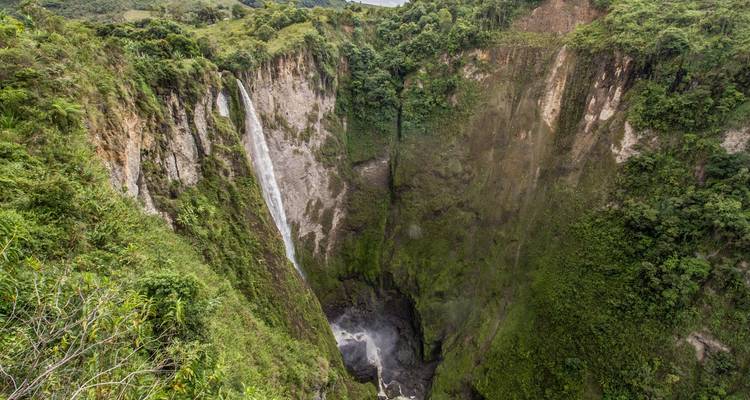 Cascade majestueuse dévalant dans une gorge profonde entourée d'une végétation luxuriante.