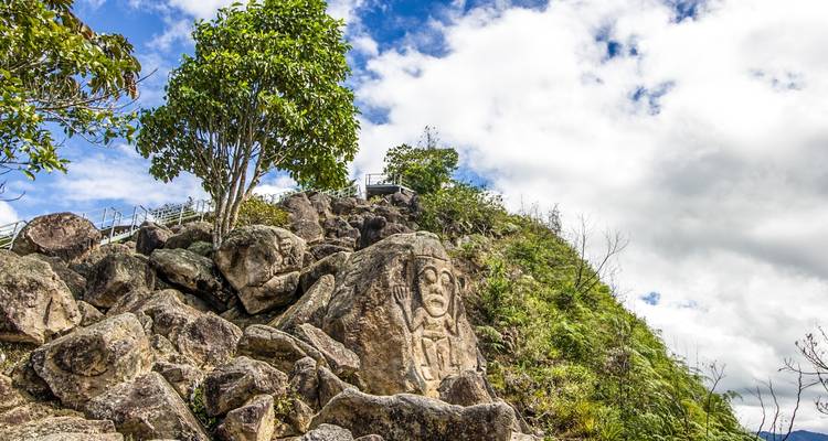 Formation rocheuse naturelle avec figure sculptée sur un fond de ciel bleu.