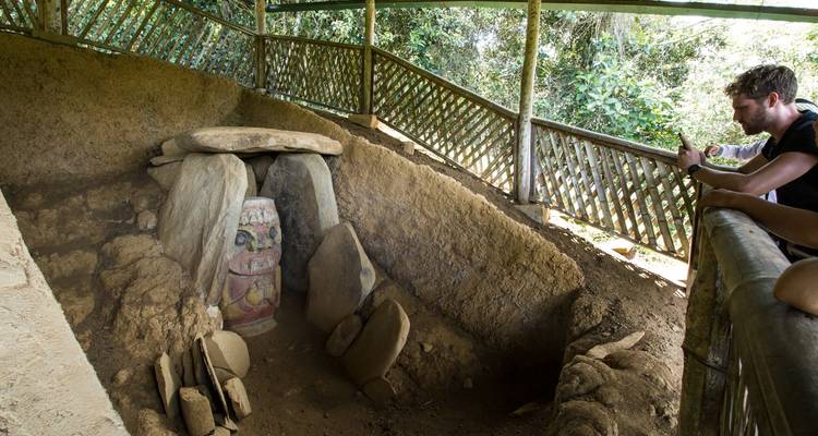 Une personne observant d'anciennes gravures sur pierre dans un site archéologique.
