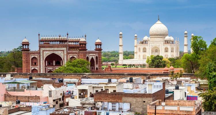 The Taj Mahal with a surrounding architectural complex under a blue sky.