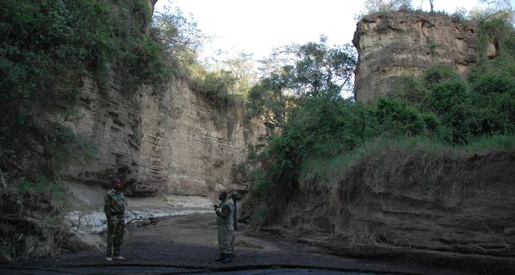 People standing in a canyon with high rock walls.