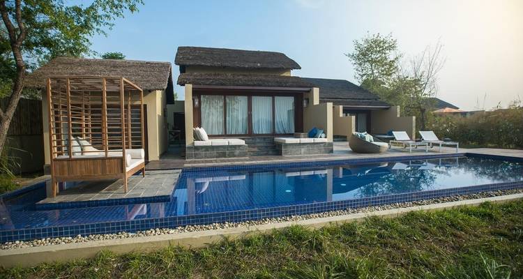 Villa de complexe hôtelier de luxe avec piscine privée et chaises longues.