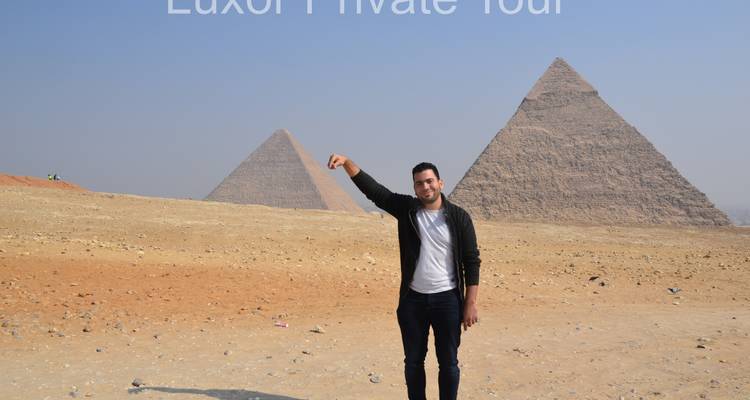 Persoon poseert met piramides op de achtergrond.