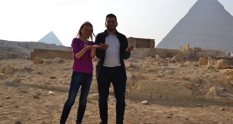 Twee mensen poseren voor piramides.