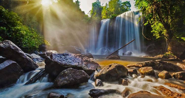 Una hermosa cascada realzada por la luz del sol y la vegetación exuberante.
