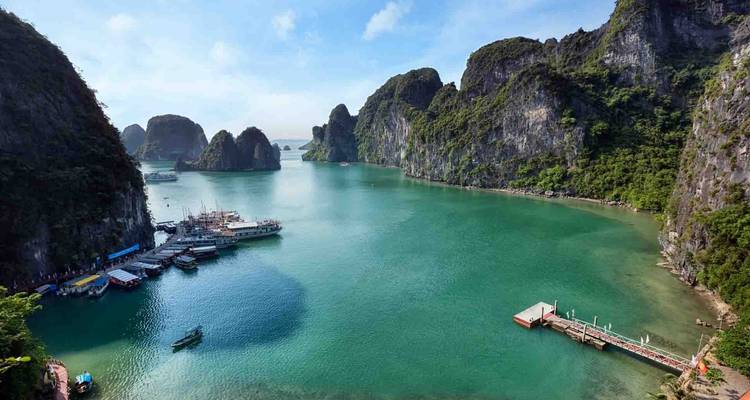 Aerial view of a vibrant blue bay surrounded by limestone cliffs.