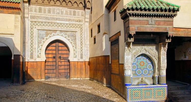 Arquitectura intrincada que muestra una gran puerta ornamentada y azulejos decorativos.