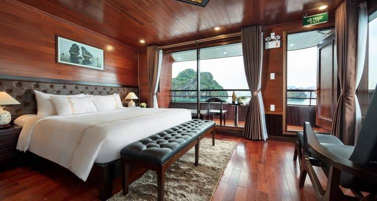 Luxe hut kamer met uitzicht op Halong Bay door grote ramen.