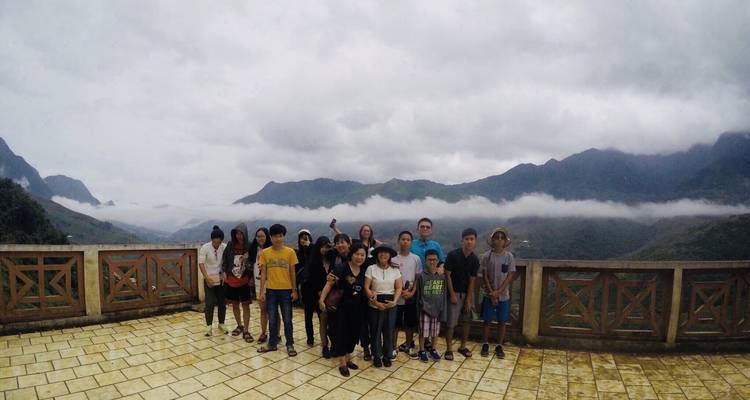 Gruppe von Menschen, die vor einer nebligen Berglandschaft posieren.