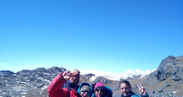 Group of people posing on a snowy mountain landscape.