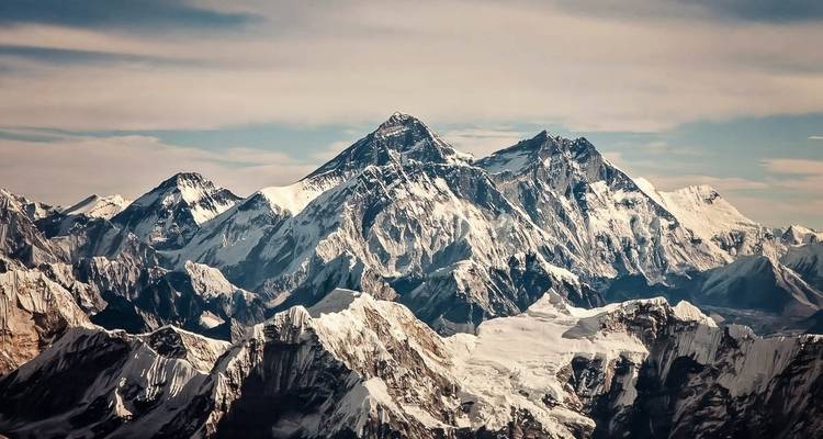 Snow-covered peak of Mount Everest under clear skies.