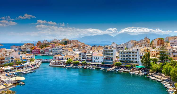 Un port avec des bateaux à Agios Nikolaos, Crète sous un ciel bleu dégagé.