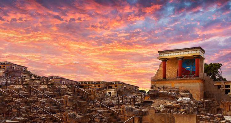 Ruines antiques du palais de Cnossos avec un ciel de coucher de soleil dramatique.