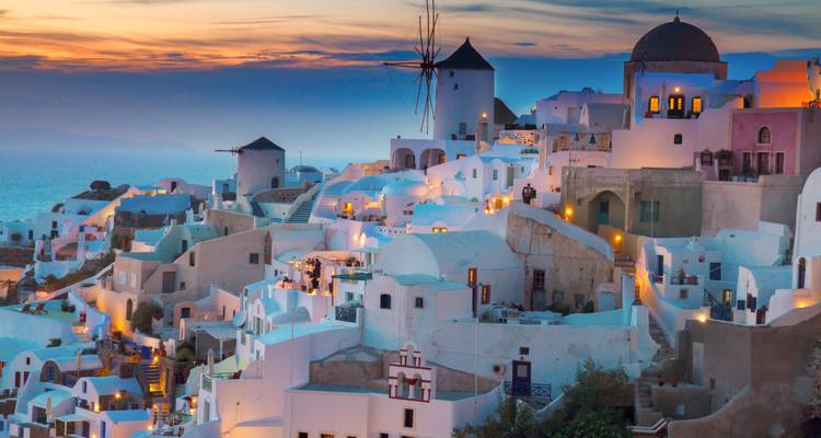 Santorin-Dorf mit weißen Gebäuden bei Sonnenuntergang.